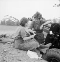 A British gunner of a 25-pounder battery talks to a French farm girl on 20 July 1944.