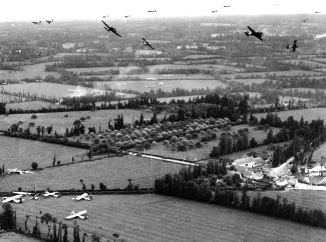 American C-47 Dakotas swirl over a typical stretch of Norman countryside, over the Cotentin Peninsula, with hedgerows and trees bordering fields, after cutting loose their CG-4A gliders over Landing Zone W, between Les Forges and Sébeville/Les Fontaines. The French N13 highway runs through the center of the image while the town of St-Mère-Église is two miles away (to the left in the photograph). The aircraft were participating in Operation “Elmira,” the reinforcement of the US 82nd Airborne Division on the evening of June 6, 1944. (AP)