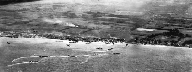 An aerial photograph of the “Sword” beach sector showing Hermanville and with le Breche located in the right third of the picture, near the patch of white on a field. The middle part of the picture, where landing craft are clustered, shows the “Queen Red” beachfront.