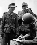 A captured Georgian from the German 795th Ost Battalion gives his name to a US Army captain at “Utah” Beach. At the time, American troops believed the man was a Japanese soldier in German uniform. In the years after the war he was identified as a “Yang Kyoungjong,” a Korean national inducted into the Russian Red Army, who was in turn captured by the German Army in 1942. The theory went on speculate that “Kyoungjong” immigrated to the United States after the war, where he died in the 1990s. The man’s facial features, however, reveal him to be a member of the ethnic minorities of Georgia. (US Office of Public and International Affairs)